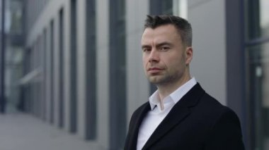 Ciddi bir erkek CEO 'nun portresi başını çevirip kameraya bakıyor. Dışarıda poz veren 40 'lı yaşlarda yakışıklı bir adam. İş ve başarı kavramı.