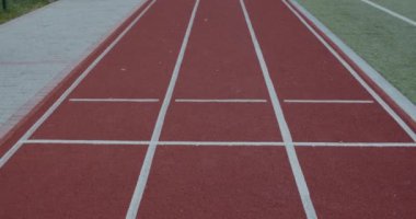 Spor sahasında otururken protez koşu bıçaklarıyla gerinen engelli bir adam. Ampüte edilmiş bacağı ısınan ve dışarıda egzersiz yapan bir erkek. Özürlü kavramı.