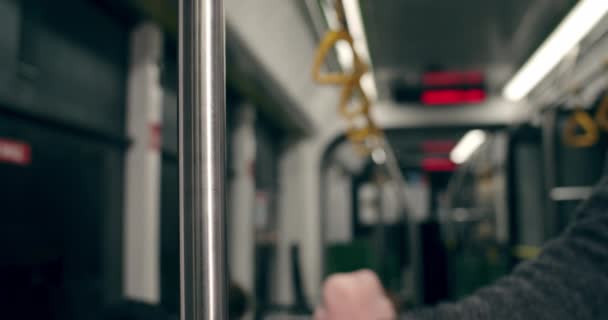 Crop view van mannelijke hand houden leuning in tram of bus. Begrip woonwerkverkeer, openbaar vervoer. — Stockvideo