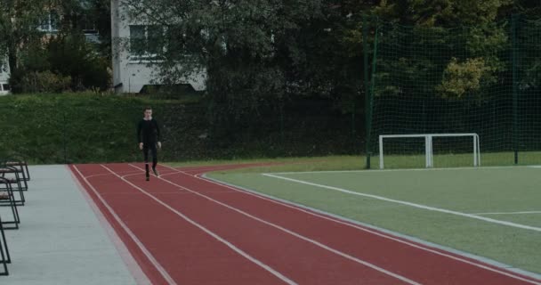 Homme handicapé motivé avec lame prothétique fonctionnant sur le terrain de sport. Jeune sportif masculin amputé en costume d'entraînement jogging à l'extérieur. Concept de séquences sportives motivationnelles. — Video