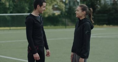 Güzel bir kadınla iletişim kurarken gülümseyen protez bıçaklı engelli bir adam. Ampüte edilmiş bacağı ve spor salonunda konuşan neşeli erkek sporcu..