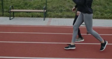 Engelli erkek ve kadın sporcuların yerlerini alıp koşmaya başladıklarını görüyorum. Koşu bıçağıyla koşan erkek sporcu ve stadyumda yarış pistinde koşan kadın..