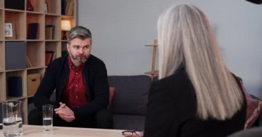 Olgun, ciddi bir adamın ofisinde terapistiyle konuşması. Terapi seansında kadının önünde oturan yakışıklı erkek sakallı adam. İnsan sorunları kavramı, depresyon.