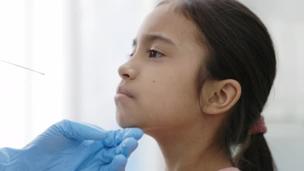 Coronavirus testi. Koruyucu eldivenli bir tıp çalışanı küçük kızdan PCR testi örneği alıyor. Covid araştırma ve tanı konsepti. PCR tanı yöntemi kavramı, hızlı covid testi. — Stok video
