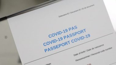 Karton COVID-19 Aşı Kartı 'na pul yapıştıran tıbbi işçinin el görüntüsü koronavirüs aşısı dozunu takip ediyor..