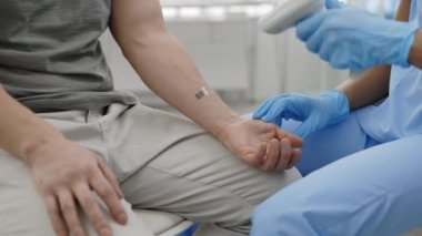 Tıbbi çalışanın koruyucu eldivenlerdeki ekin görüntüsü aşıyı yapmadan önce hastanın kolundaki barkodu tarıyor. Aşı programı kavramı, bulaşıcı hastalıkların önlenmesi.