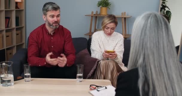 Crop view of married couple having therapy session in female family counselor. Husband discussing internet addiction problems and taking phone from his wife while they in specialist. — Stock Video