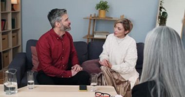 Evli duygusal çiftin kadın psikolog ofisinde otururken aile sorunlarını tartışması. Karı koca terapi seansı sırasında kadın uzmanın önünde kavga ediyorlar..