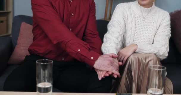 행복 한 남자와 여자가 심리학자 사무실에 앉아 있는 동안화 해 하고 포옹하는 모습을 볼 수있다. 웃고 손을 잡고 있는 긍정적 인 커플. 관계, 가족의 개념. — 비디오