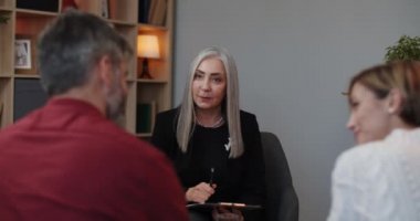 Neşeli kadın terapistin evli bir çiftle seans yapması ön planda. Olgun kadın psikolog müşterileriyle aile sorunlarını tartışıyor. İlişki kavramı.