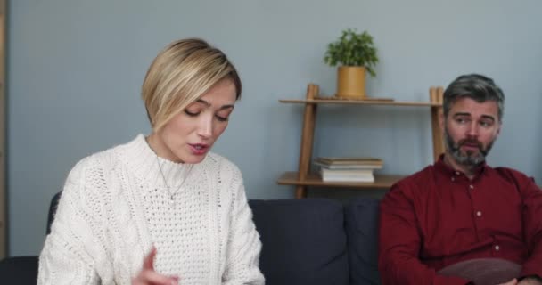 Närbild av gifta par dela familjeproblem. Kvinnan pratar och hennes man grimaserar under terapisessionen. Begreppet förhållande. — Stockvideo