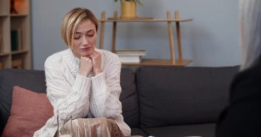 Endişeli bir kadının ofiste terapistiyle konuşması. Terapi seansında psikologun önünde oturan mutsuz bir kadın. İnsan sorunları kavramı, depresyon.