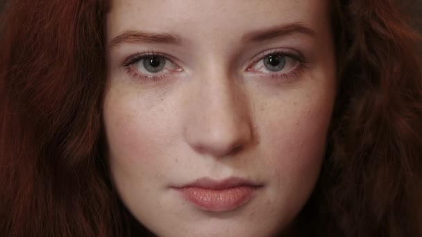 Vue rapprochée de la jeune femme aux cheveux roux face à la caméra. Portrait de belle femme aux yeux bleus posant. Concept de headshot. — Video