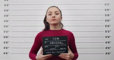 Polis departmanında at kuyruklu kadın suçlunun portresi. Milenyum kadınının poz verme, başını kaldırma ve kameraya bakma görüntüsü..