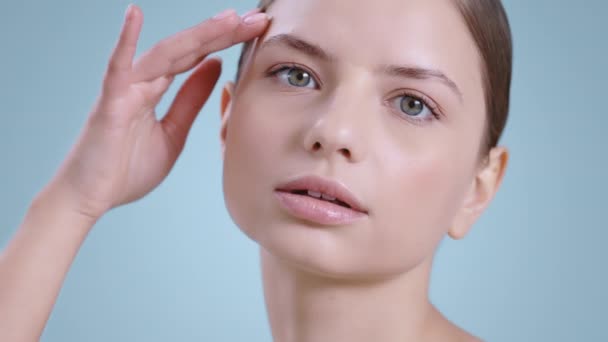 Headshot of pretty woman turning head and looking to camera while touching face with one hand . Female attractive model with nude make up posing . Concept of cosmetology, skincare. — Stock video
