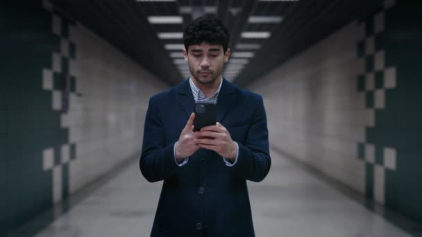 Glücklicher Geschäftsmann mit Smartphone im U-Bahn-Tunnel — Stockvideo