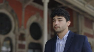 Şehir caddesinde yürüyen takım elbiseli kendine güvenen bir adam.