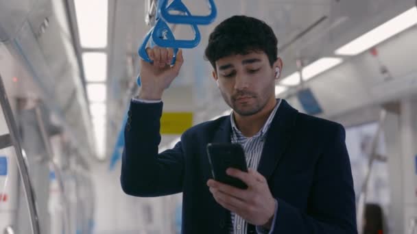 Pengusaha dengan earphone menggunakan smartphone di subway — Stok Video