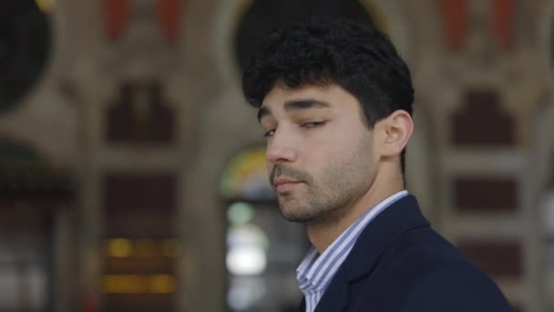 Hombre guapo con mirada penetrante de pie al aire libre — Vídeos de Stock