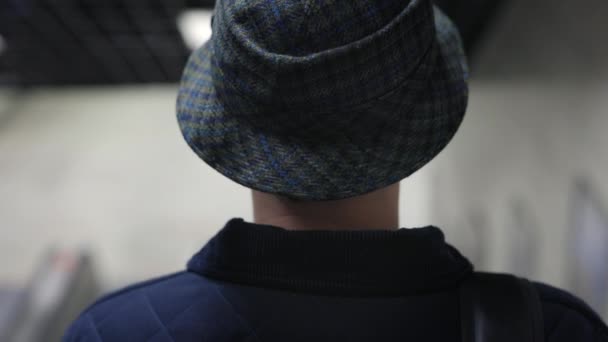 Visão traseira do homem elegante em chapéu de balde andando escada rolante — Vídeo de Stock
