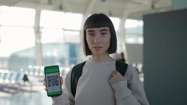 Mujer mostrando pasaporte de salud en el móvil en el aeropuerto — Vídeo de stock
