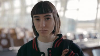 Havaalanında poz veren sırt çantalı bir kadın portresi.