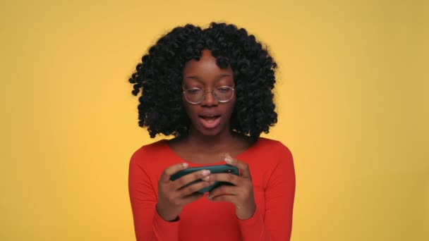 Mulher muito africana jogando jogos online no smartphone — Vídeo de Stock