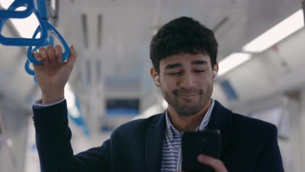 Man genieten van favoriete liedjes in oortelefoons tijdens de metro rijden — Stockvideo