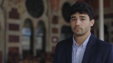 Şık giyinmiş düşünceli bir adam sokakta yürüyor.