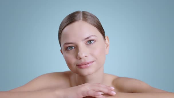 Portrait de femme millénaire attrayante penché vers l'avant tout en regardant à la caméra. Jolie modèle féminin avec des épaules nues et lumière nue maquillage posant à l'arrière-plan du studio. — Video