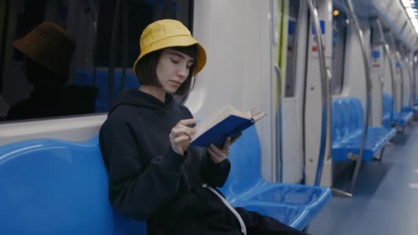 地铁火车上快乐的女通勤者看书 — 图库视频影像