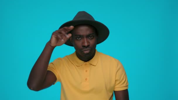 Стильний чоловічий хіпстер, що регулює чорний капелюх і жестикулює — стокове відео