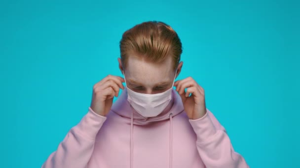 Snygg kille med rött hår tar av medicinsk mask — Stockvideo