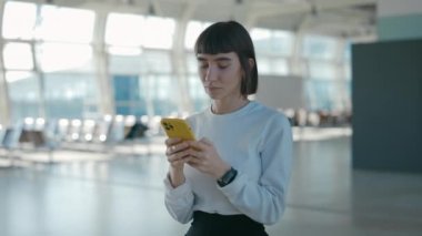 Kalkışı beklerken cep telefonunda yazan kadın.