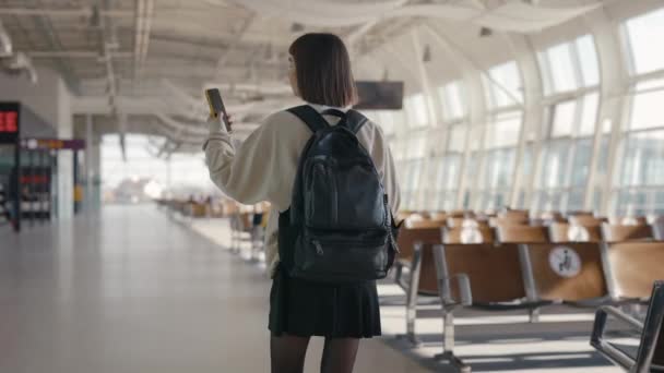 Touristin benutzt Handy beim Gehen am Flughafen — Stockvideo