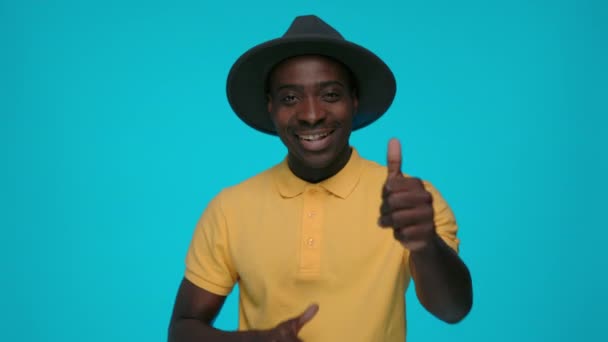 Чорний хлопець жестикулює з великими пальцями на синьому фоні — стокове відео