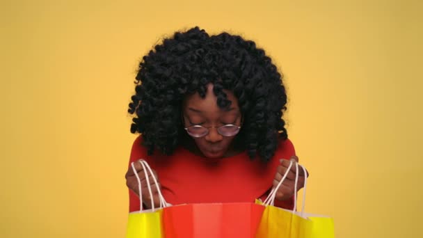 Emotional woman standing at studio with shopping bags — Vídeo de Stock