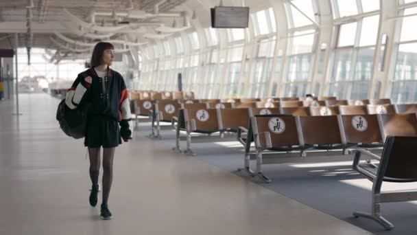 Stilvolle Frau mit Kurzhaarschnitt spaziert am leeren Flughafen — Stockvideo