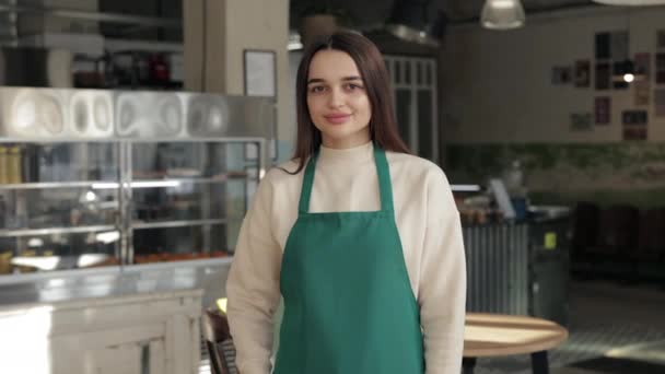 Garçom feminino em avental verde posando no café local — Vídeo de Stock