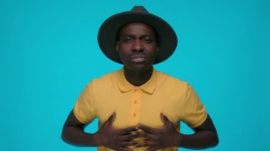 Afrikalı adam göğsüne dokunuyor.