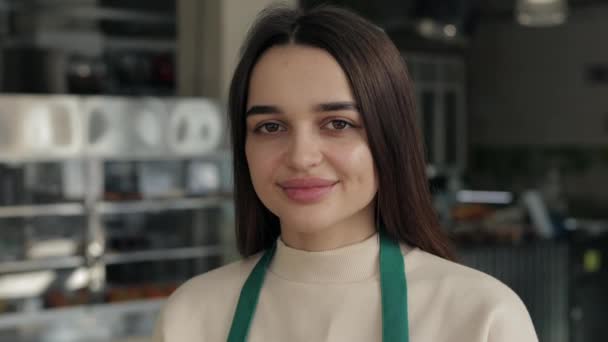 Портрет чарівної офіціантки в фартуху позує в кафе — стокове відео
