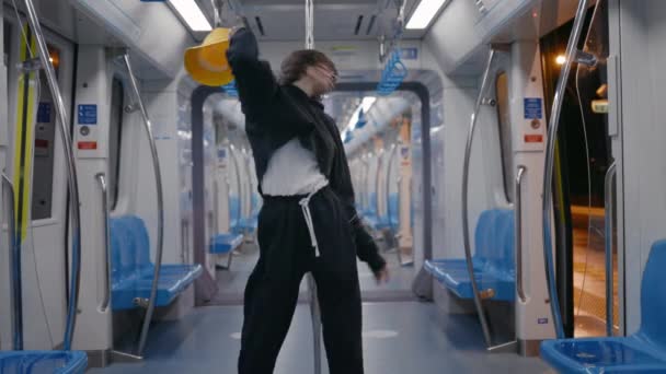 Lviv, Ukraine - 21. März 2021: Unbekümmerte Frau mit Kopfhörern tanzt in leerer U-Bahn — Stockvideo