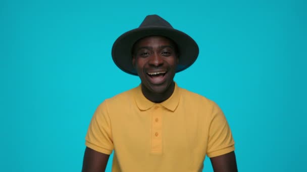 Elegante chico africano sonriendo sinceramente sobre fondo azul — Vídeos de Stock