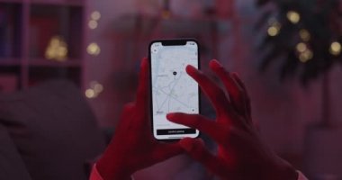 Lviv, Ukraine - February 05, 2021: Close up of male hands holding mobile and using Uber Taxi