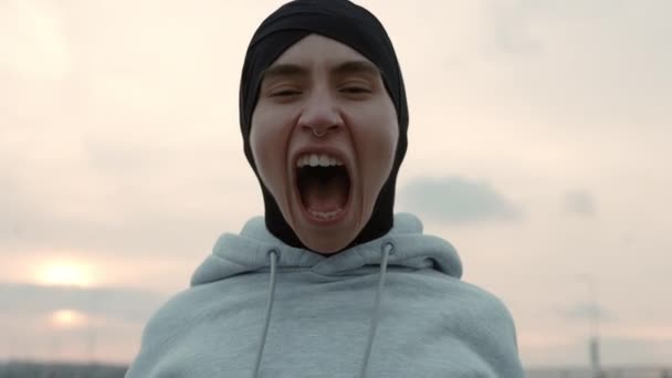 Portrait of woman in hijab screaming with anger outdoors — Stockvideo