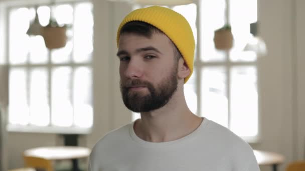 一个头戴时髦黄色帽子的英俊的高加索男人在咖啡店前摆姿势 — 图库视频影像