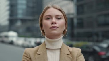 Sokakta poz veren sarı saçlı çekici iş kadını.