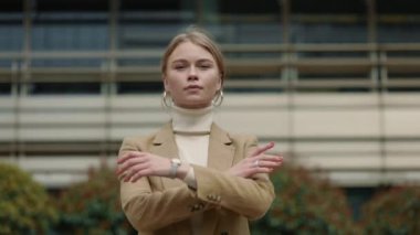 Dışarıda kollarını kavuşturmuş bir iş kadını.