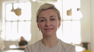 Mutlu yaşlı kadın rahat bir restoranda poz veriyor.