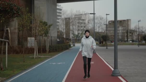 Fuerte mujer activa en hijab corriendo en camino de asfalto — Vídeos de Stock